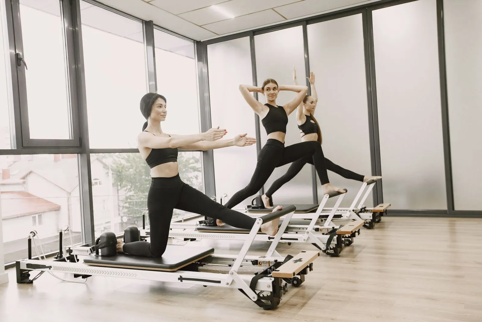 Clase de pilates reformer en un estudio luminoso